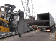 loading wooden poles into containers